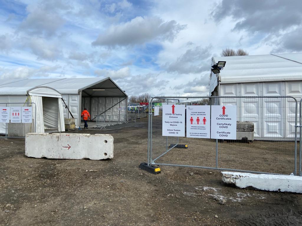A haulier COVID-19 testing site set up for the Department for Transport, with marquees, fencing and signage in English, Polish and Romanian